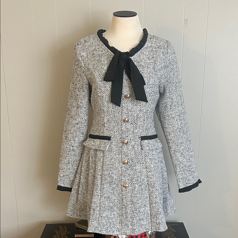 Sweet fitted weaved black and white dress with black ruffles trim and a bow.